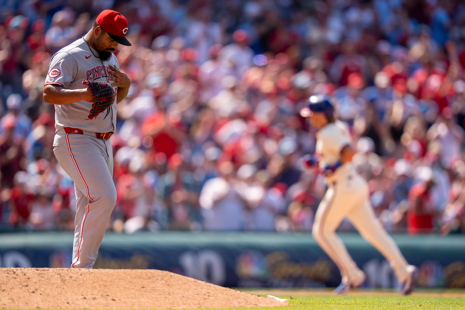 Cincinnati Reds relief pitcher Tony Santillan, left, reacts as Philadelphia Phillies' Bryson Stott, right, rounds the bases after hitting a two-run home run during the eighth inning of a baseball game, Sunday, July 6, 2025, in Philadelphia. (AP Photo/Chris Szagola)