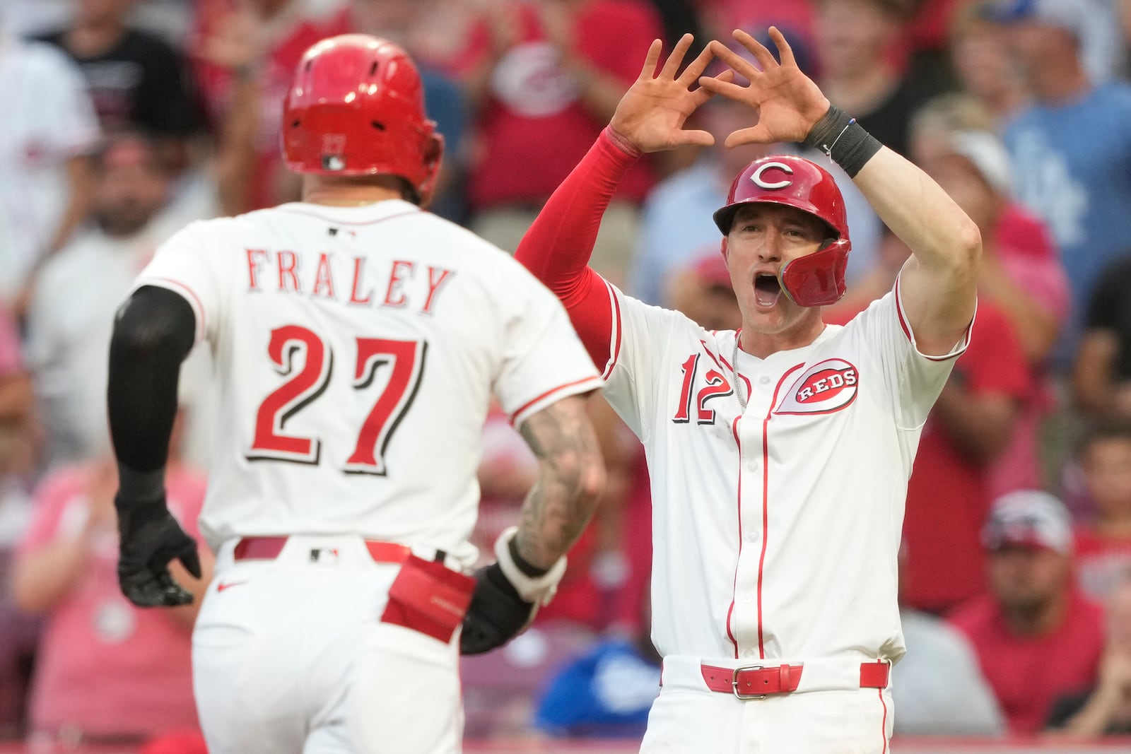 Cincinnati Reds' Austin Hays (12) celebrates Jake Fraley's (27) two-run homer during the fourth inning of a baseball game against the Los Angeles Dodgers, Tuesday, July 29, 2025, in Cincinnati. (AP Photo/Carolyn Kaster)