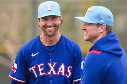 Texas Rangers pitcher Jacob deGrom (left) laughs with Josh Sborz during a spring training...
