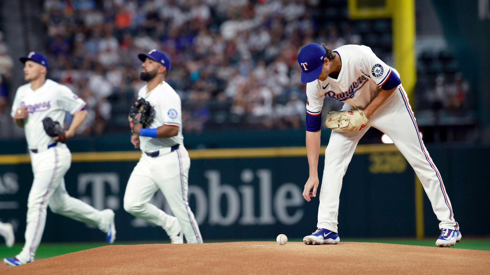 Texas Rangers starting pitcher Jacob deGrom (48) reaches for the baseball as the team takes...