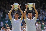 Julian Cash of Britain, left, and Lloyd Glasspool of Britain celebrate with the trophy after...