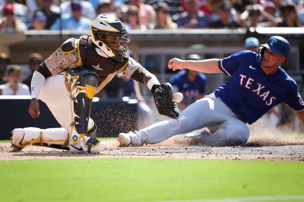 Corey Seager #5 of the Texas Rangers scores a run ahead of the throw to Martin Maldonado #15 of the San Diego Padres during the third inning at Petco Park on Friday, July 4, 2025 in San Diego, CA. (Meg McLaughlin / The San Diego Union-Tribune)