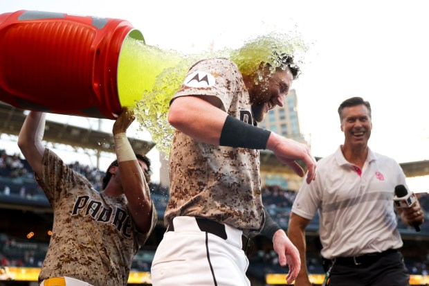 Tyler Wade #14 of the San Diego Padres douses Jake Cronenworth #9 in sports drink after Croneworth's walk-off single against the Texas Rangers during the tenth inning at Petco Park on Friday, July 4, 2025 in San Diego, CA. (Meg McLaughlin / The San Diego Union-Tribune)
