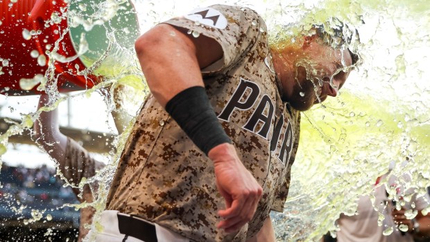 Tyler Wade #14 of the San Diego Padres douses Jake Cronenworth #9 in sports drink after Croneworth's walk-off single against the Texas Rangers during the tenth inning at Petco Park on Friday, July 4, 2025 in San Diego, CA. (Meg McLaughlin / The San Diego Union-Tribune)