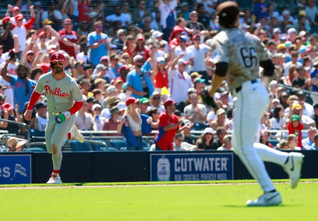 Bryce Harper #3 of the Philadelphia Phillies scores in the eighth inning on a J.T. Realmuto double as David Morgan #13 of the San Diego Padres looks on at Petco Park on July 13, 2025 in San Diego, California. (Photo by K.C. Alfred / The San Diego Union-Tribune)