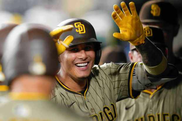 San Diego Padres' Manny Machado celebrates with teammates in the dugout after he hits a grand slam against the Washington Nationals during the ninth inning of a baseball game at Nationals Park, Friday, July 18, 2025, in Washington. (AP Photo/Jess Rapfogel)