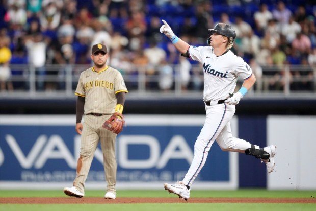 Miami Marlins' Kyle Stowers runs past San Diego Padres second base Jose Iglesias as he rounds the bases after hitting a single-run homer in the fourth inning of a baseball game against the San Diego Padres, Monday, July 21, 2025, in Miami. (AP Photo/Rebecca Blackwell)