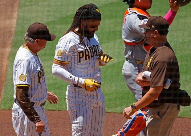 Fernando Tatis Jr. #23 of the San Diego Padres reacts after he was hit by a pitch on the hand in second inning against as manager Mike Shildt, left, looks on against the New York Mets at Petco Park on July 30, 2025 in San Diego, CA. (K.C. Alfred / The San Diego Union-Tribune)