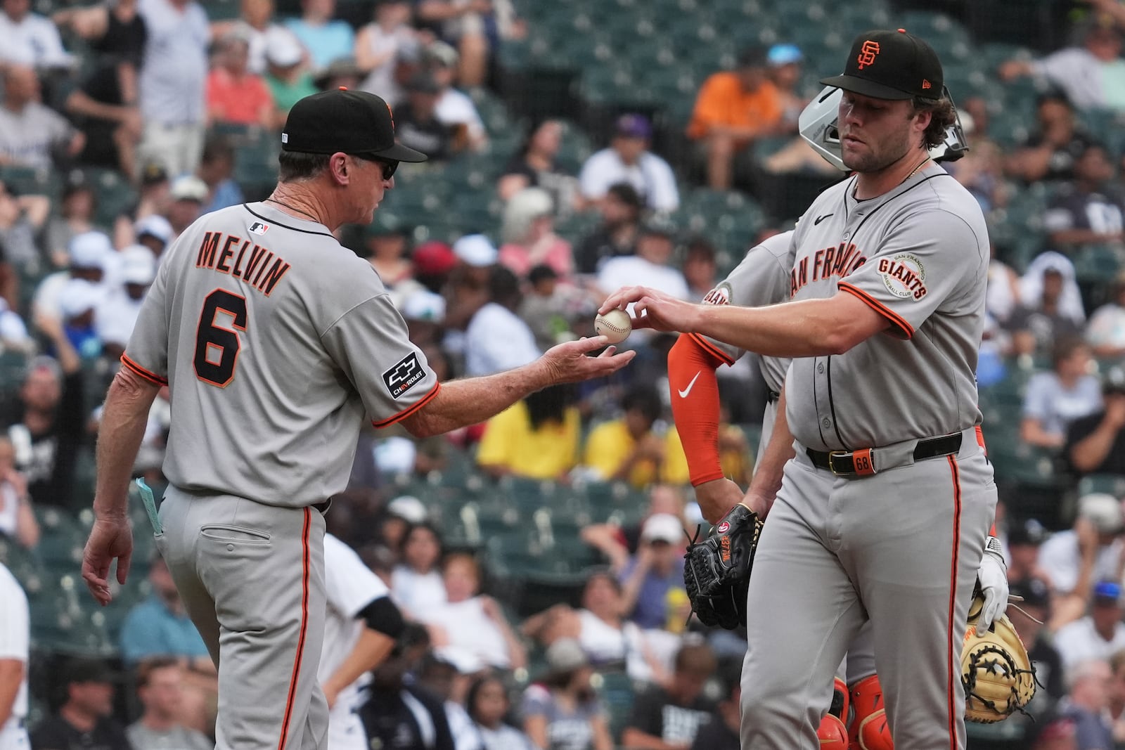 San Francisco Giants manager Bob Melvin, left, takes the ball from relief pitcher pitcher Erik Miller during the seventh inning of a baseball game against the Chicago White Sox in Chicago, Sunday, June 29, 2025. (AP Photo/Nam Y. Huh)
