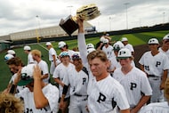 Prosper catcher Easton Carmichael (11) hoists up the area trophy after his team’s victory as...
