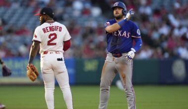 Texas Rangers first baseman Jake Burger, right, cannot make the tag on San Diego Padres' Luis Arraez, left, on a single during the second inning of a baseball game Friday, July 4, 2025. (AP Photo/Denis Poroy)
