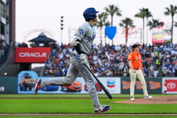 Los Angeles Dodgers' Shohei Ohtani, left, watches his two-run home run during the third inning of a baseball game against the San Francisco Giants, Friday, July 11, 2025, in San Francisco. (AP Photo/Godofredo A. Vásquez)
