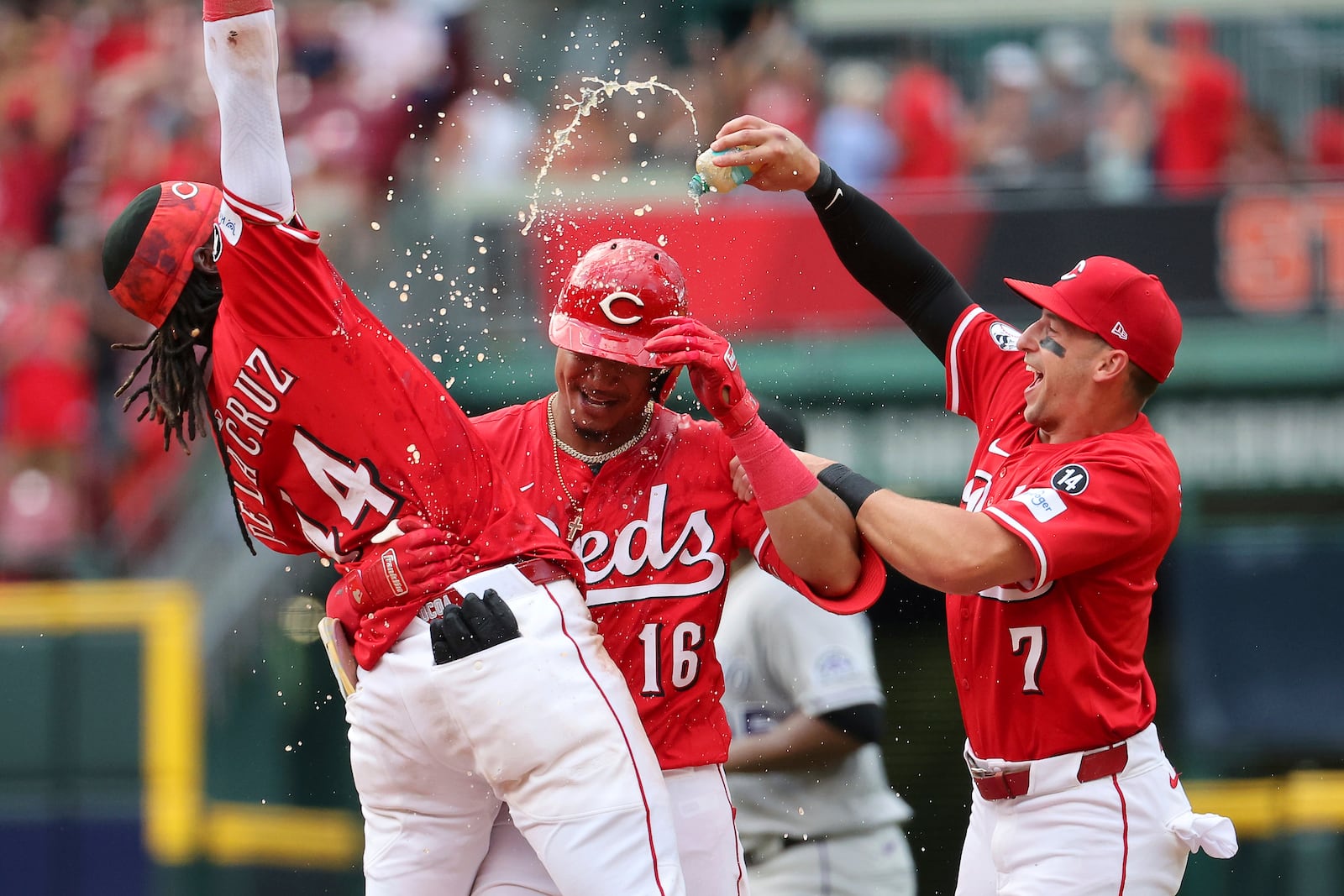 Cincinnati Reds' Noelvi Marte (16) celebrates with Elly De La Cruz (44) and Spencer Steer (7) after driving in the game-winning run in the ninth inning of a baseball game against the Colorado Rockies, Saturday, July 12, 2025, in Cincinnati. (AP Photo/Joe Maiorana)