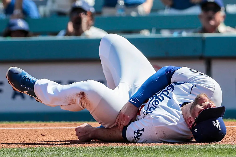 Dodgers first baseman Max Muncy writhes in pain after colliding with the Brewers' Jace Peterson during the last game of 2021.