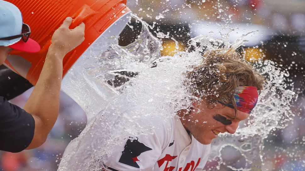 Minnesota Twins' Harrison Bader is doused by teammates after his winning solo home run against the Tampa Bay Rays in the ninth inning of a baseball game Friday, July 4, 2025, in Minneapolis. (AP Photo/Bruce Kluckhohn)