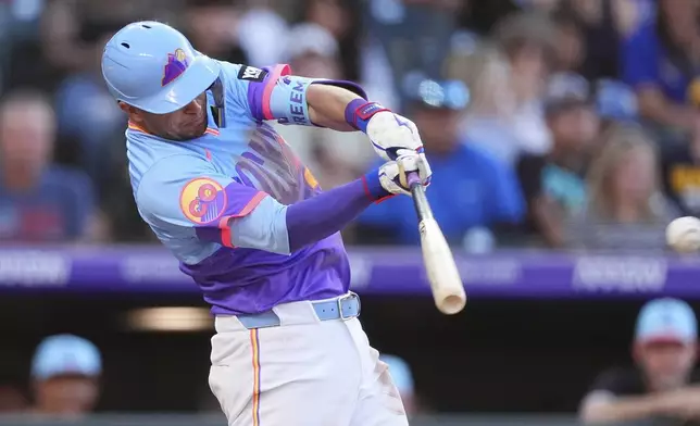 Colorado Rockies' Tyler Freeman doubles to drive in a run off Chicago White Sox starting pitcher Adrian Houser in the fifth inning of a baseball game Friday, July 4, 2025, in Denver. (AP Photo/David Zalubowski)