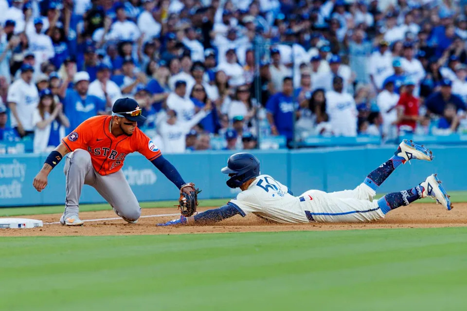 Dodgers shortstop Mookie Betts is tagged out by Houston Astros third base Isaac Paredes.