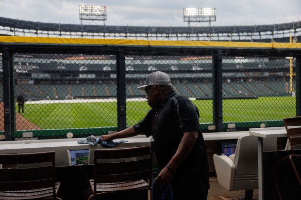 A worker cleans water from a table after rain passed through the area before the White Sox play the Toronto Blue Jays at Rate Field Tuesday July 8, 2025, in Chicago. (Armando L. Sanchez/Chicago Tribune)