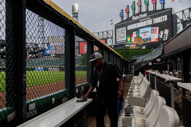 A worker cleans water from a table after rain passed through the area before the White Sox play the Toronto Blue Jays at Rate Field Tuesday July 8, 2025, in Chicago. (Armando L. Sanchez/Chicago Tribune)