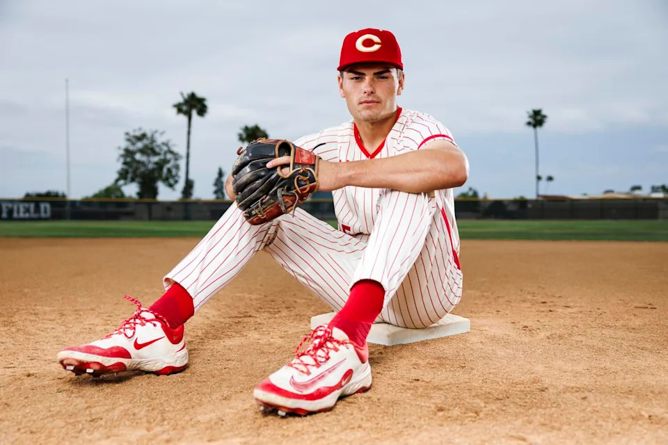Brady Ebel of Corona High poses for a photo while sitting on a baseball field.