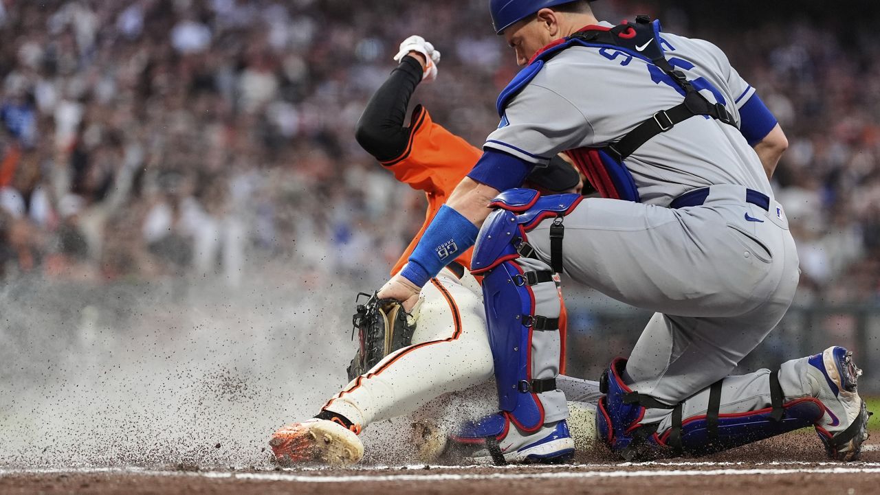Los Angeles Dodgers catcher Will Smith, right, tags out San Francisco Giants' Jung Hoo Lee at home to end the fourth inning of a baseball game Friday, July 11, 2025, in San Francisco. (AP Photo/Godofredo A. Vásquez)