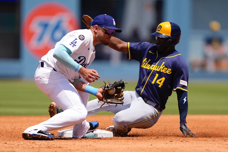 Milwaukee Brewers' Andruw Monasterio, right, slides into second while advancing after Blake Perkins scored on his single as Los Angeles Dodgers second baseman Miguel Rojas takes a late throw during the fourth inning of a baseball game Sunday, July 20, 2025, in Los Angeles. (AP Photo/Mark J. Terrill)