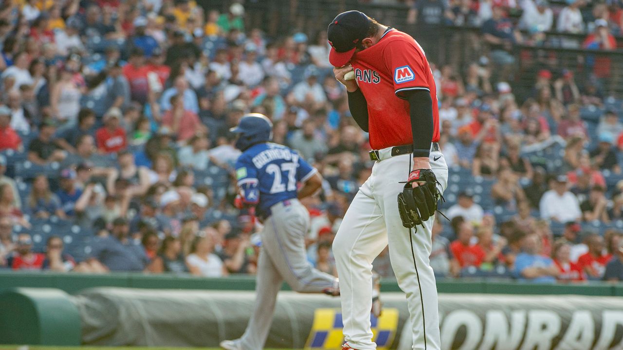 Cleveland Guardians starting pitcher Gavin Williams, front, reacts after giving up a solo home run as Toronto Blue Jays' Vladimir Guerrero Jr. (27) rounds the bases during the fourth inning of a baseball game, Wednesday, June 25, 2025, in Cleveland. (AP Photo/Phil Long)