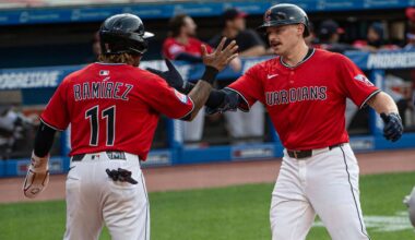 Colorado Rockies' Orlando Arcia (11) is tagged out between third base and home plate by Cleveland Guardians first baseman Carlos Santana, right, in the fifth inning of a baseball game in Cleveland, Monday, July 28, 2025. (AP Photo/Sue Ogrocki)