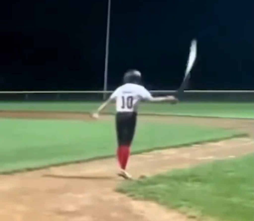 Little league baseball player flipping their bat.