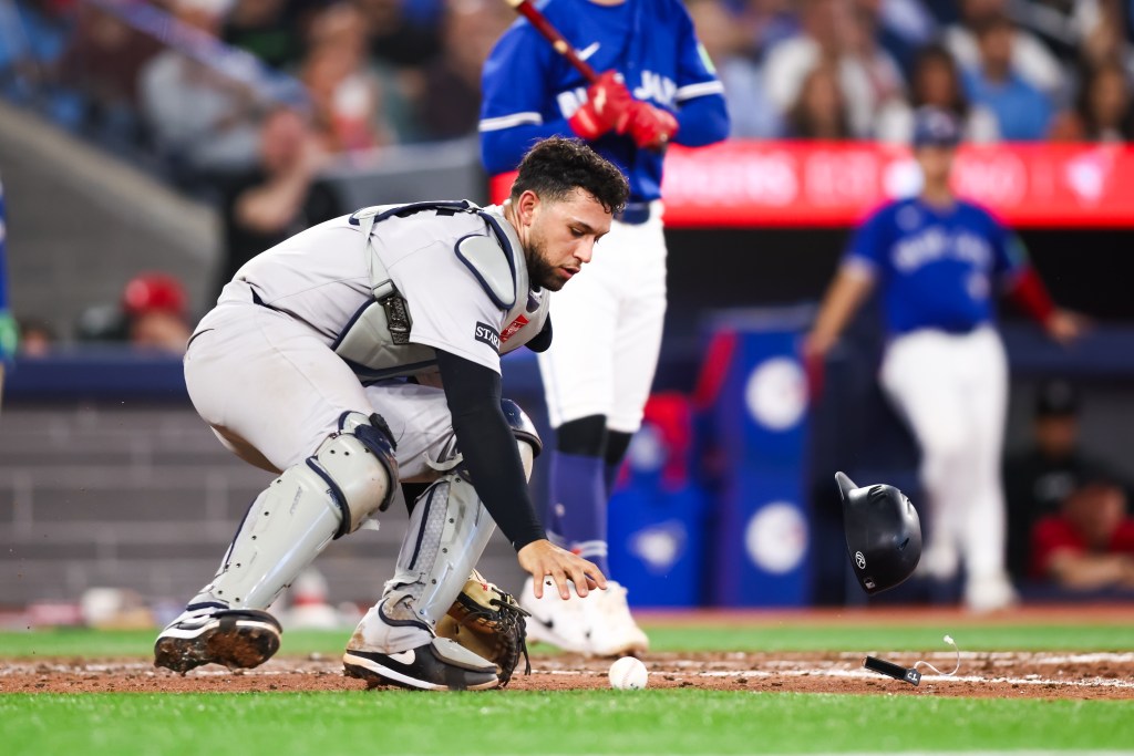 New York Yankees catcher reaching for a wild pitch.