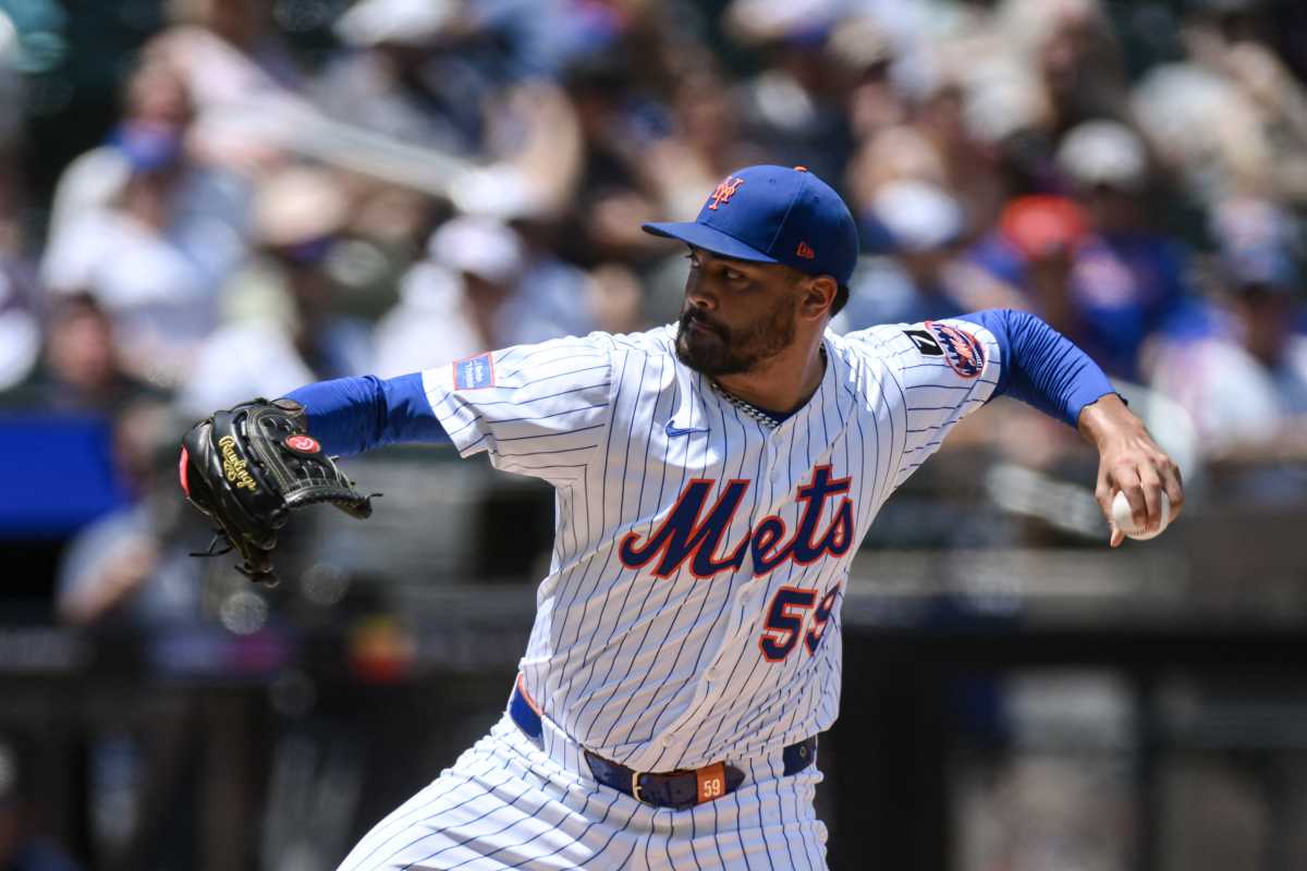 Man in Mets uniform throwing baseball