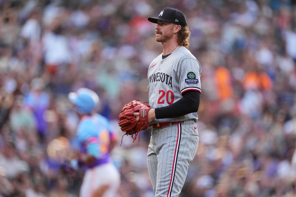 Minnesota Twins starting pitcher Chris Paddack, front, reacts as Colorado Rockies' Jordan Beck circles the bases after hitting a solo home in the second inning of a baseball game Friday, July 18, 2025, in Denver. 