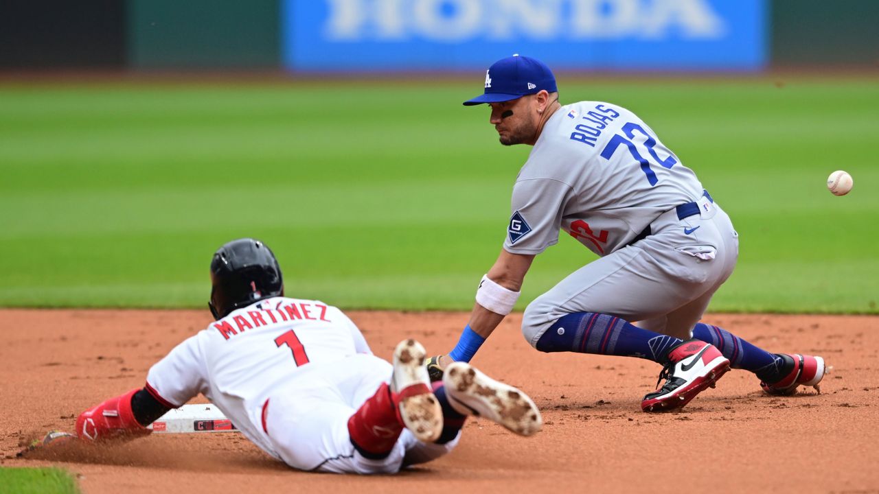Cleveland Guardians' Angel Martinez slides safely into second base for a double as Los Angeles Dodgers second baseman Miguel Rojas misplays the baseball during the first inning of a baseball game, Wednesday, May 28, 2025, in Cleveland.