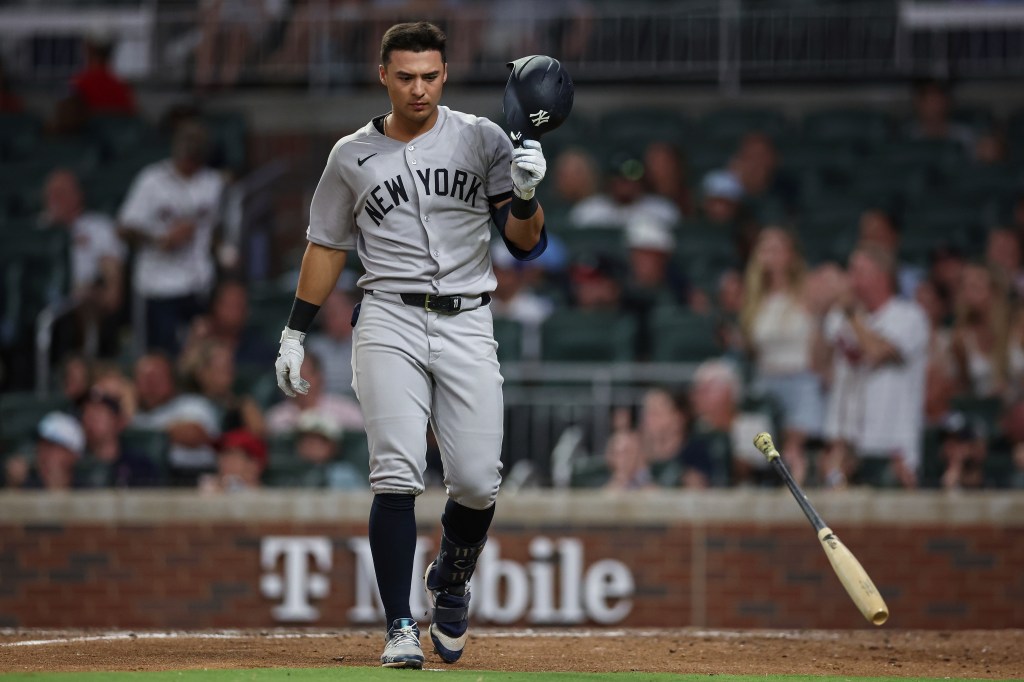 New York Yankees player Anthony Volpe walks off the field after striking out.