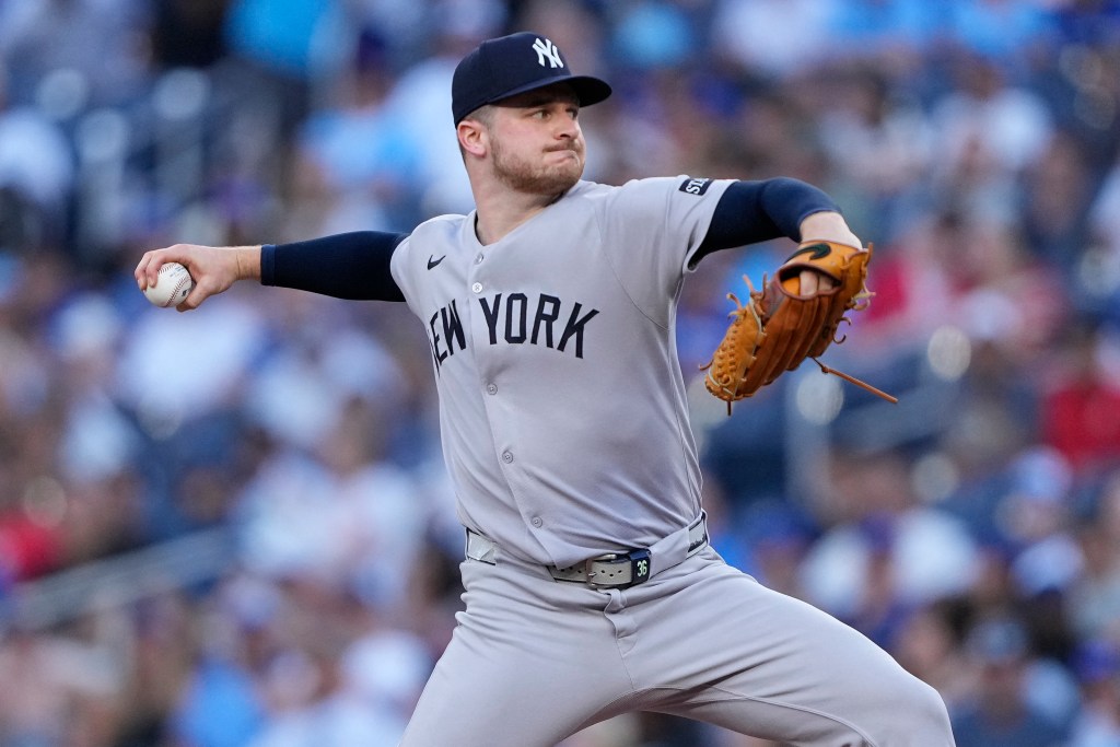 New York Yankees pitcher Clarke Schmidt pitching a baseball.