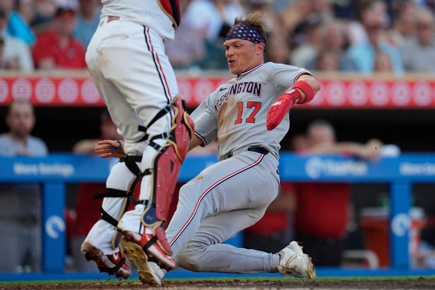 Washington Nationals' Alex Call (17) slides to score off a two-run double by CJ Abrams during the fifth inning of a baseball game against the Minnesota Twins, Saturday, July 26, 2025, in Minneapolis. (AP Photo/Abbie Parr)