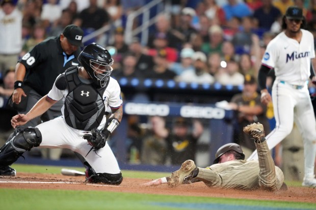 The Padres' Jackson Merrill slides in to home past Marlins catcher Agustín Ramírez to score on a double by the Martín Maldonado in the second inning of Monday's game at loanDepot park. (AP Photo/Rebecca Blackwell)