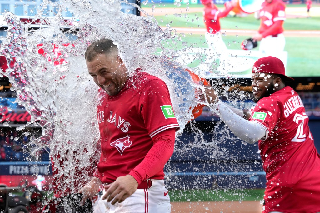 Vladimir Guerrero Jr. pouring water on George Springer after a Blue Jays win.