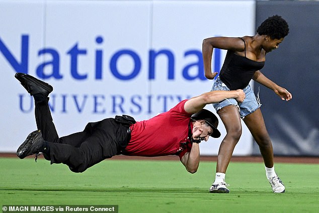A security guard tackles a fan who ran on the field during the ninth inning of a game between the San Francisco Giants and San Diego Padres at Petco Park. She was the second to do so