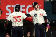 Texas Rangers' Adolis Garcia (53) celebrates with Jonah Heim (28) after scoring on a single...