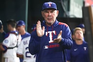 Texas Rangers manager Bruce Bochy remains in the dugout during the third inning of a...