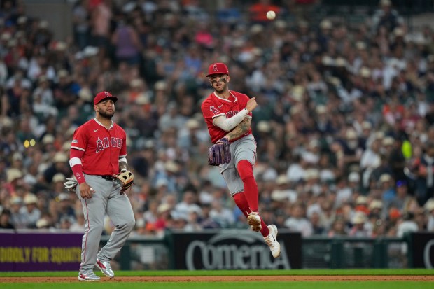 Angels shortstop Zach Neto, right, throws out Detroit Tigers’ Andy...