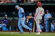 Texas Rangers starting pitcher Patrick Corbin, left, follows a slow-rolling ball hit by...