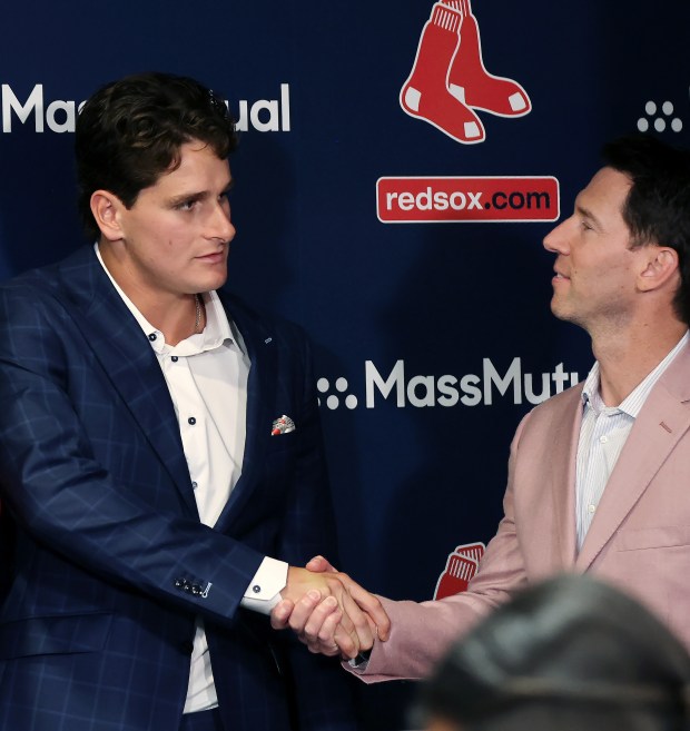 Boston, MA: Boston Red Sox rookie outfielder Roman Anthony (left) signed an eight year contract with the team. At a press conference before tonight's game he is pictured shaking hands with with Craig Breslow (right). (Jim Davis/Boston Herald).