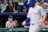 Texas Rangers manager Bruce Bochy claps in the dugout as Wyatt Langford scores on a single...