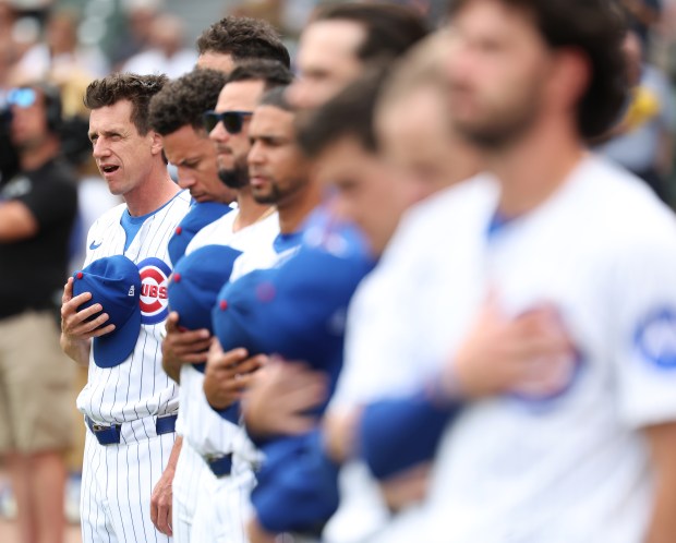 Chicago Cubs manager Craig Counsell (left) and his team stand for the national anthem before the start of Game 1 of a doubleheader against the Milwaukee Brewers at Wrigley Field in Chicago on Aug. 19, 2025. (Chris Sweda/Chicago Tribune)