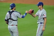 Texas Rangers' catcher Kyle Higashioka and relief pitcher Hoby Milner celebrate after their...