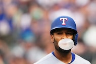 Texas Rangers' Marcus Semien blows a bubble after striking out against the Seattle Mariners...