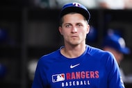 Texas Rangers shortstop Corey Seager walks in the dugout during the sixth inning of baseball...