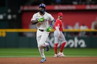 Texas Rangers' Adolis Garcia rounds the bases after hitting a three-run home run as Los...